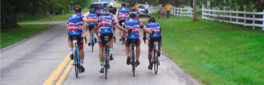 Group of cyclists riding on a road.